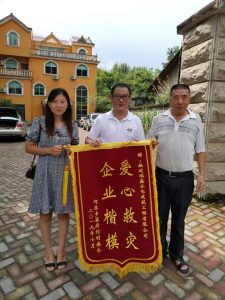 接受灾区村委授的锦旗